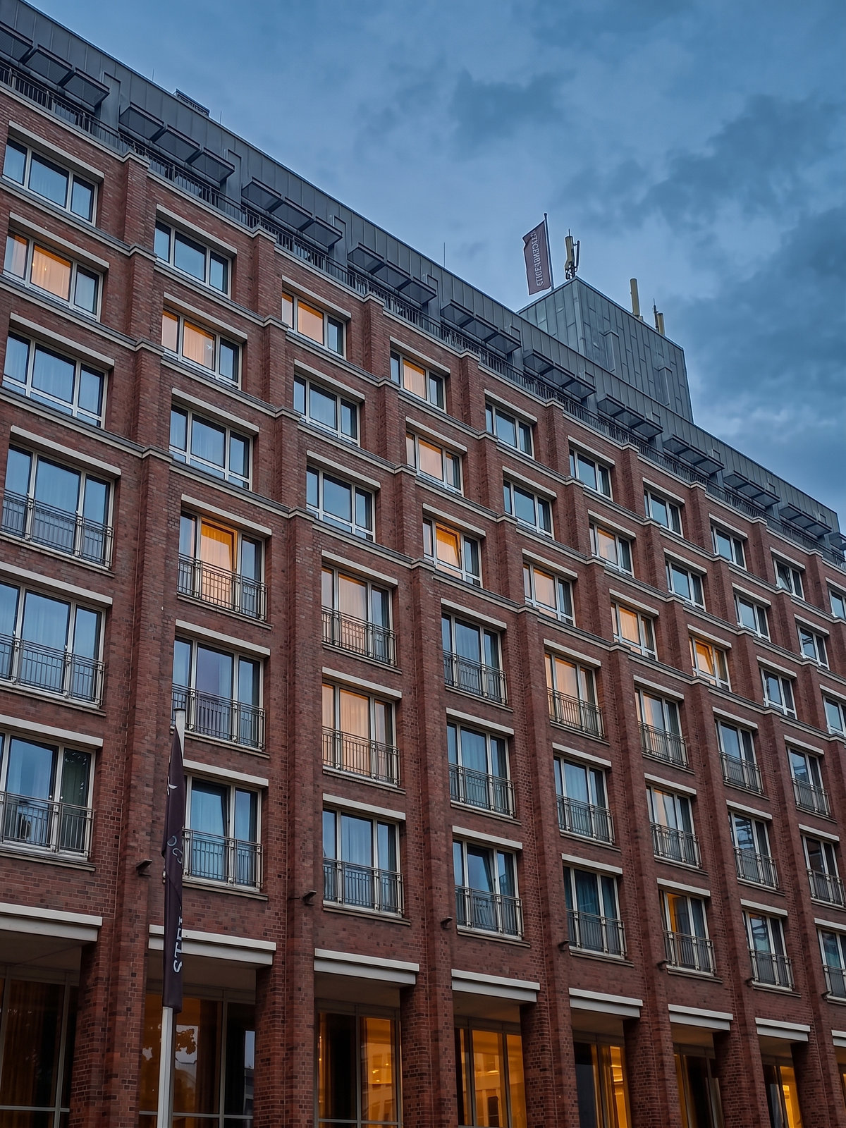 De baksteengevel van het Steigenberger Hotel bij avond