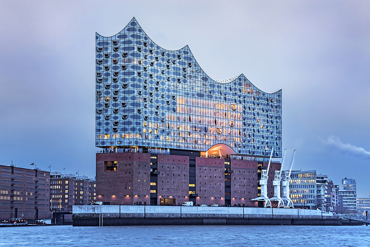 De Elbphilharmonie gezien vanaf het water, met de glazen kroon op de bakstenen basis